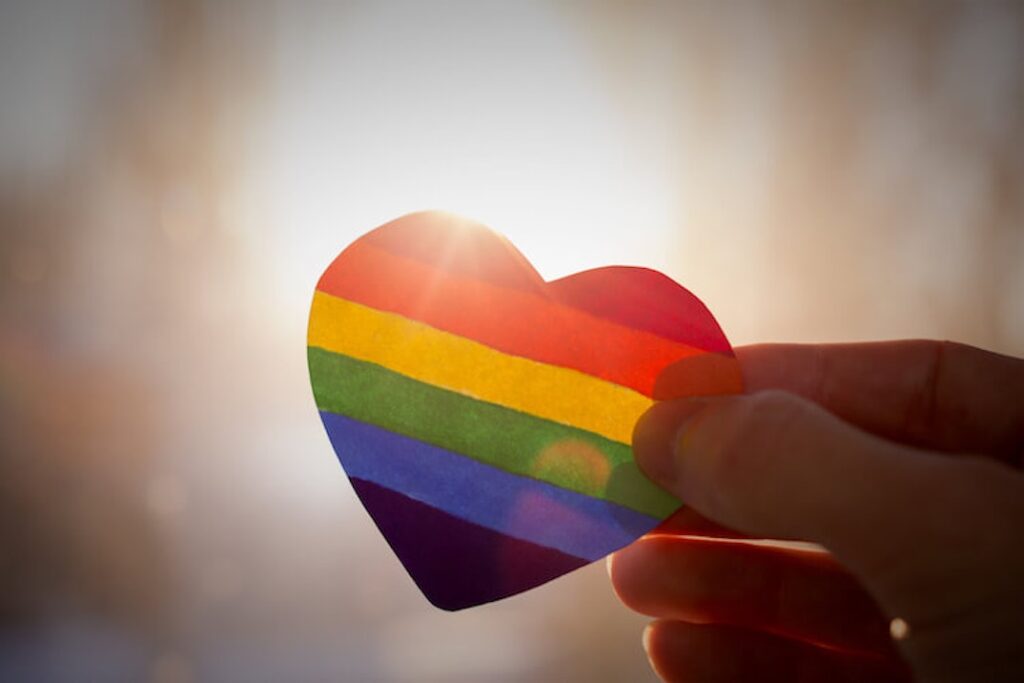 Hand holds rainbow colored heart to represent LGBTQ rights.