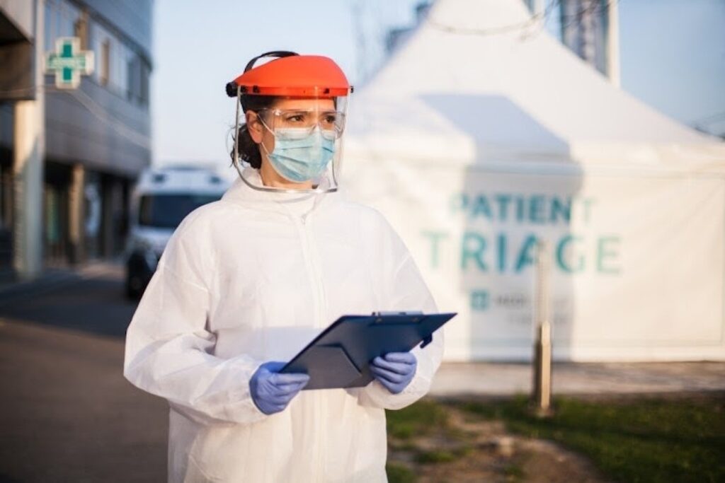A masked nurse outside a mobile health clinic.