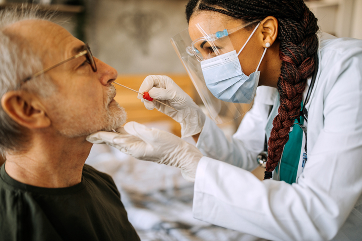 A healthcare professional uses a swab to take a sample from a patient for testing.