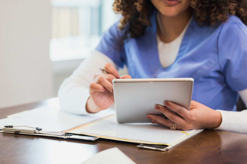 A public health expert sits at a desk reviewing a tablet