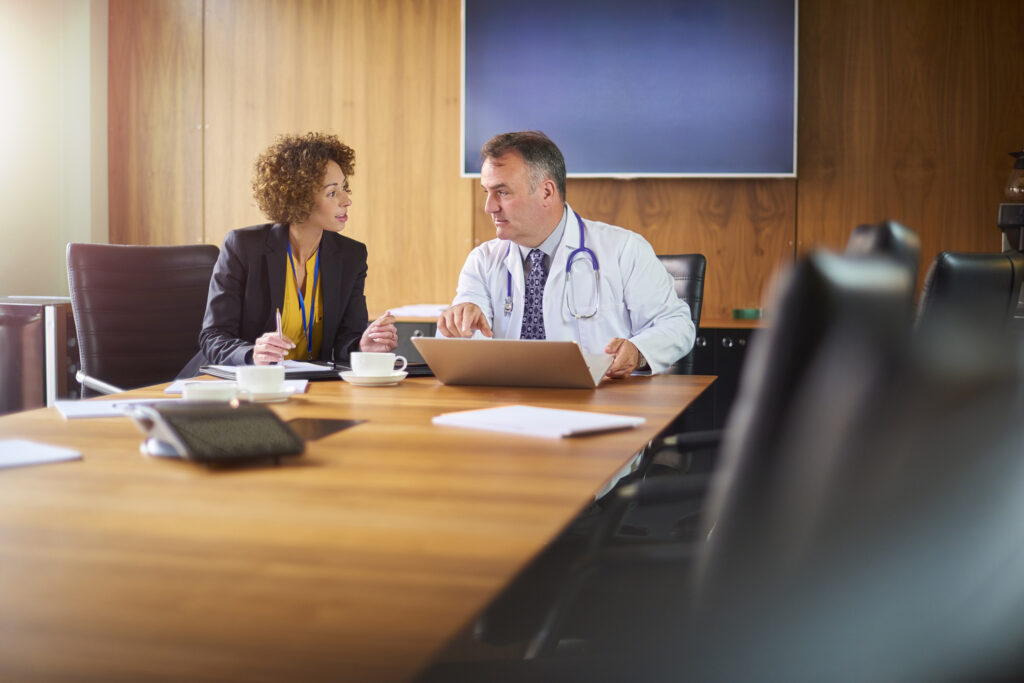 Healthcare lawyers meeting with a doctor in a conference room