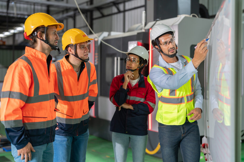 Safety professionals looking at a board in a warehouse.